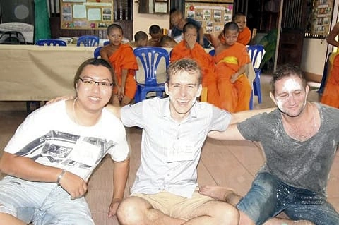 CMLocals Chiang Mai Locals Sak Yant three tourists sitting respectfully with monks in Buddhist temple